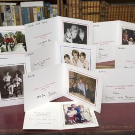 Felicitările de Crăciun ale Prințului Charles și ale Prințesei Diana aranjate pe o masă de lemn