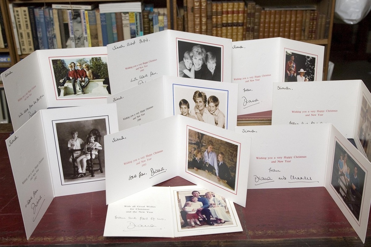 Felicitările de Crăciun ale Prințului Charles și ale Prințesei Diana aranjate pe o masă de lemn