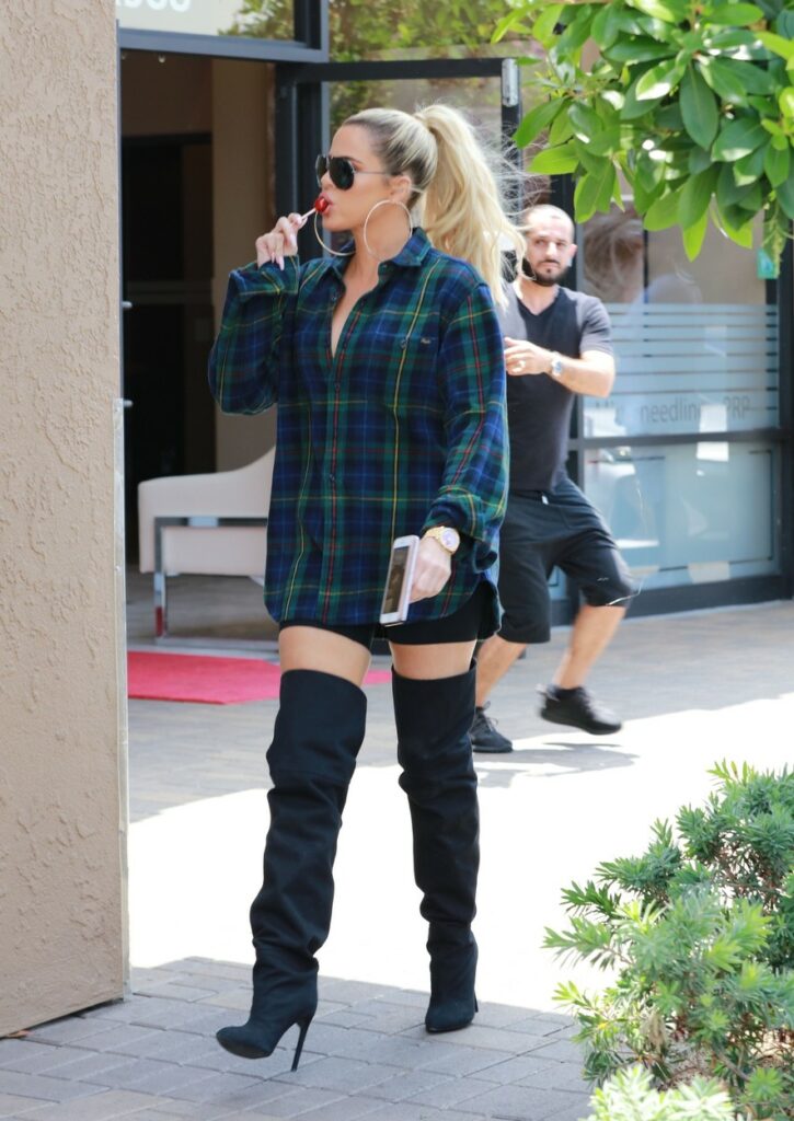 khloe kardashian se află pe stradă și mănâncă o acadea roșie