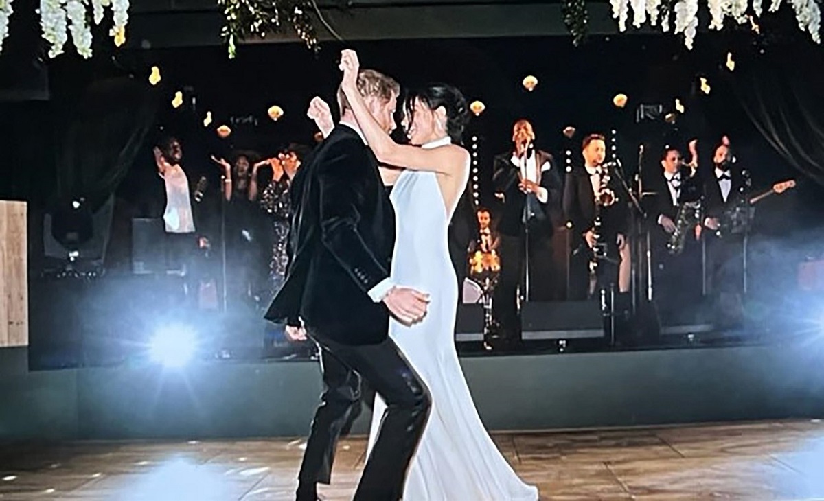 Meghan Markle în rochie de miereasă și Prințul Harry în costum dansând după nunta lor