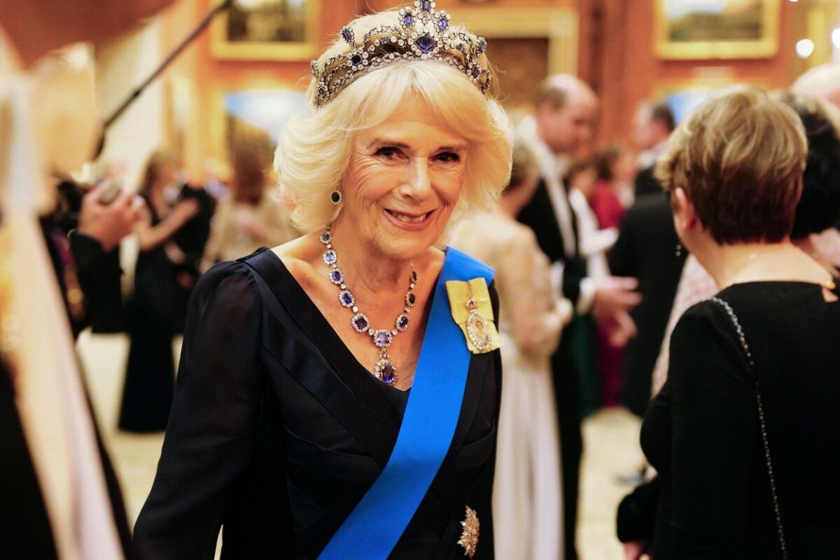 Regina Camilla, cu tiara pe cap, într-o rochie de culoare închisă