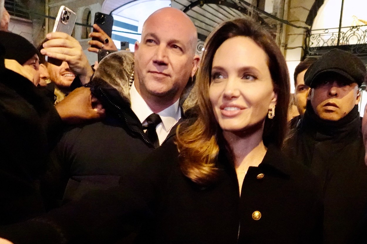 Angelina Jolie, cu un zâmbet larg, în timp ce semnează autografe pentru fani