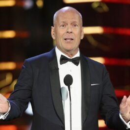 Bruce Willis la cosum pe scenă în timp ce ține un discurs, actorul a anunțat că și-a modificat testamentul