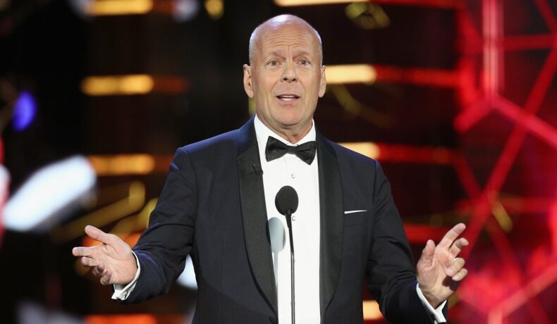 Bruce Willis la cosum pe scenă în timp ce ține un discurs, actorul a anunțat că și-a modificat testamentul