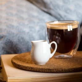 O ceașcă de cafea, servită la pat, alături de lapte