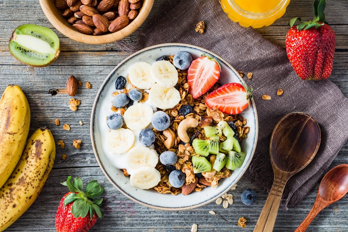 Un bol mare cu cereale și multe fructe pe care să le consumi dimineața