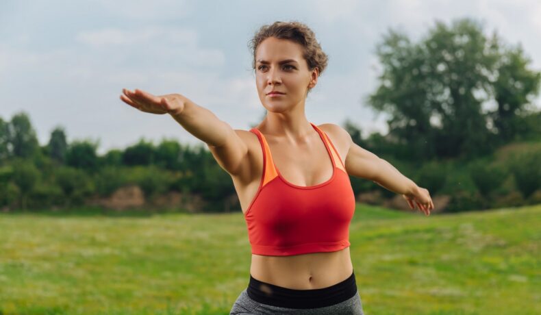 O femeie activă face sport în aer liber, unul dintre obiceiurile simple care accelerează metabolismul, în timp ce poartă un echipament sportiv de culoare portocalie.