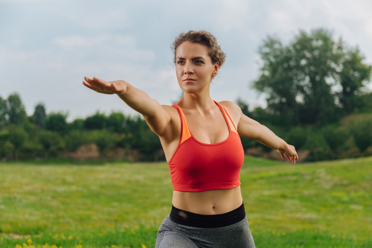 O femeie activă face sport în aer liber, unul dintre obiceiurile simple care accelerează metabolismul, în timp ce poartă un echipament sportiv de culoare portocalie.