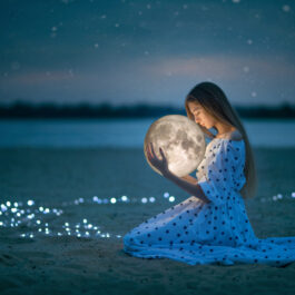 Fată frumoasă îmbrăcată într-o rochie lungă ține în brațe o lună