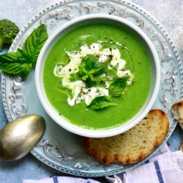 Supă cremă de broccoli într-un bol albastru reprezintă una dintre ideile pentru cină care te ajută să slăbești