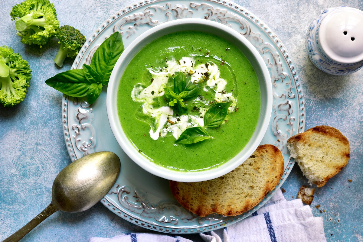 Supă cremă de broccoli într-un bol albastru reprezintă una dintre ideile pentru cină care te ajută să slăbești