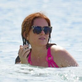 Isla Fiher, în apă, cu o pereche de ochelari de soare cu rame mari, în Barbados