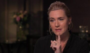 Kate Winslet, într-un interviu, cu degetul ridicat, în timp ce discută despre ceva