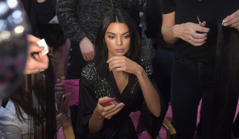 Kendall Jenner într-o rochie neagră în timp ce se pregătește pentru un show de modă