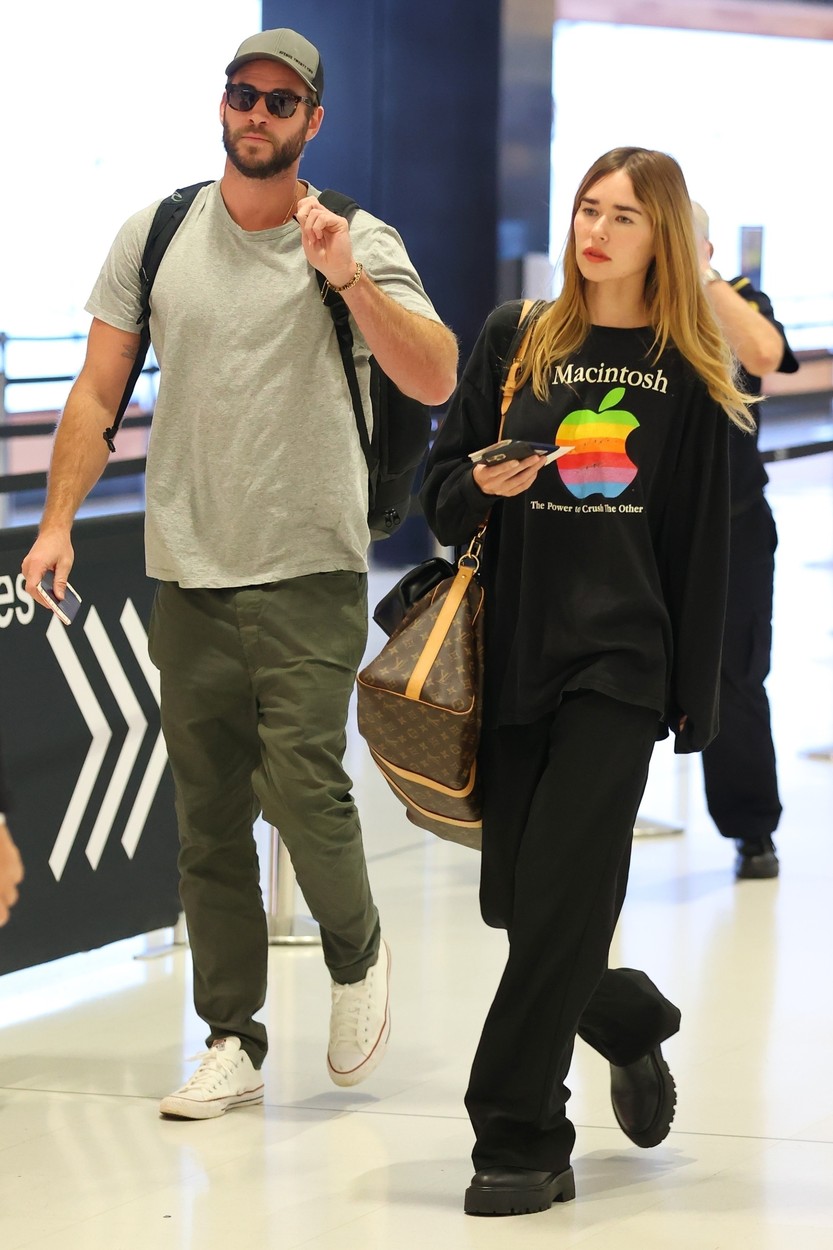 Gabriella Brooks și Liam Hemsworth, în aeroport, în haine lejere