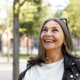 O femeie zâmbește și este fericită pentru că urmează o serie de trucuri de frumusețe pentru femeile care au peste 50 de ani