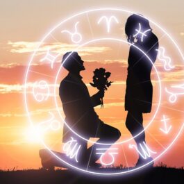 Un bărbat cere în căsătorie o femeie la apus, iar deaupra lor se află harta tuturor semnelor zodiacale compatibile pentru un mariaj fericit