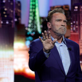 Arnold, la un show tv, în timp ce le face cu mâna celor din public