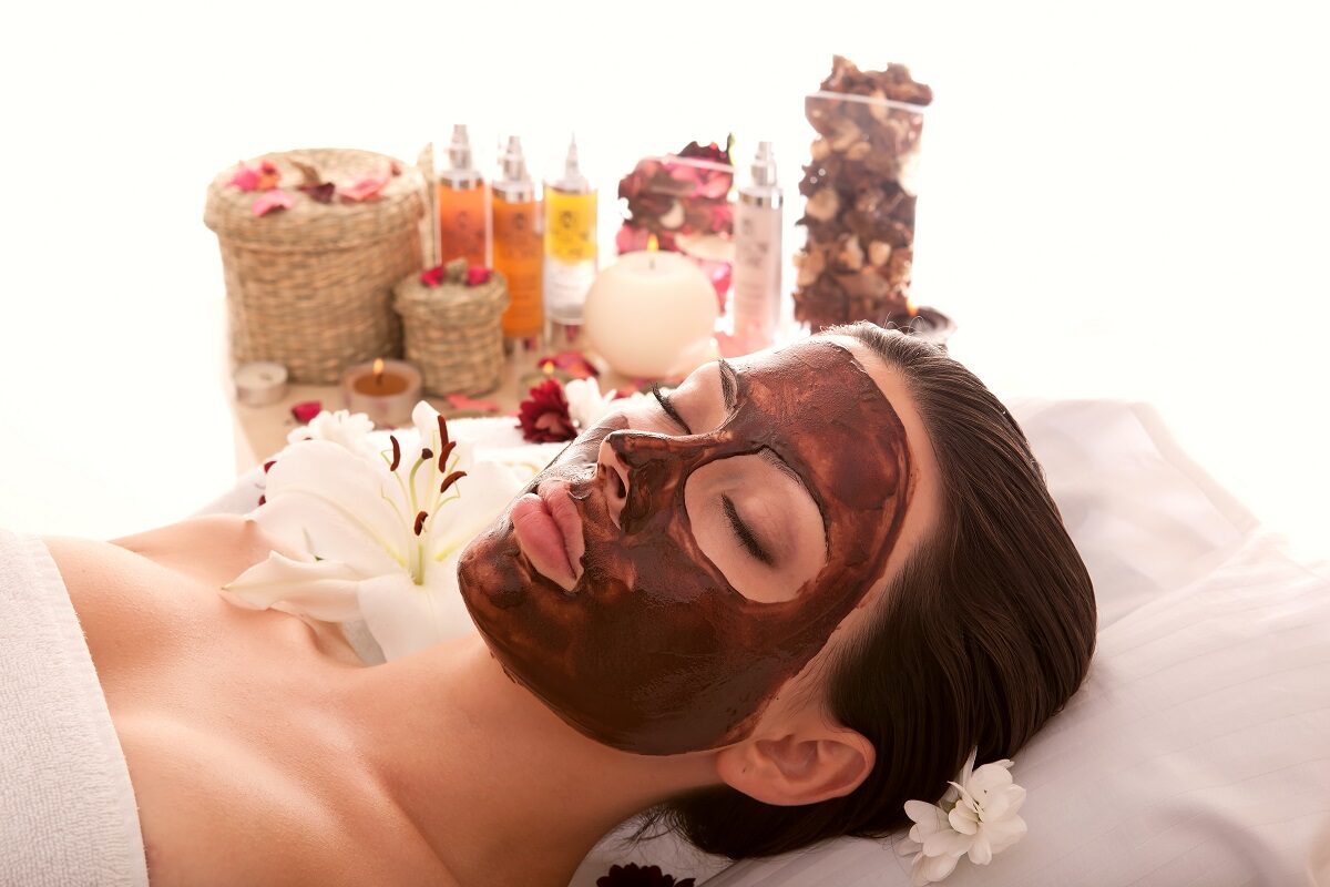 O femeie care are aplicată pe față o mască de ciocolată