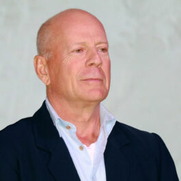 Bruce Willis, la un eveniment, într-un costum negru asortat cu o cămașă deschisă la culoare