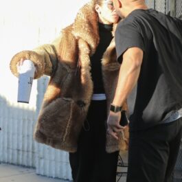 Jennifer Lopez în haină de blană în timp ce se sărută pe obraz cu un prieten pe străzile din Los Angeles