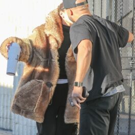 Jennifer Lopez în haină de blană în timp ce se sărută pe obraz cu un prieten