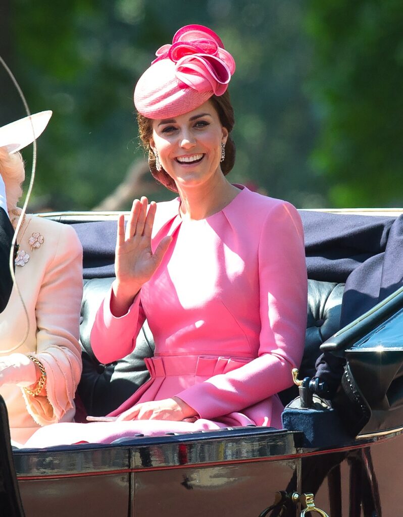 Kate Middleton poartă o rochie roz elegantă și o pălărie în aceeași nuanță în timp ce se plimbă cu caleașca regală, salutând poporul britanic