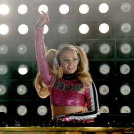 Paris Hilton, într-un top roz, cu paiete, în timp ce pune muzică la un eveniment