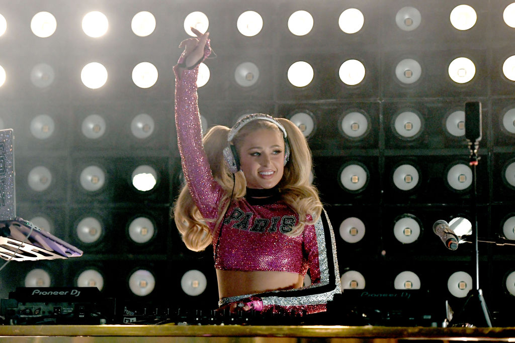 Paris Hilton, într-un top roz, cu paiete, în timp ce pune muzică la un eveniment