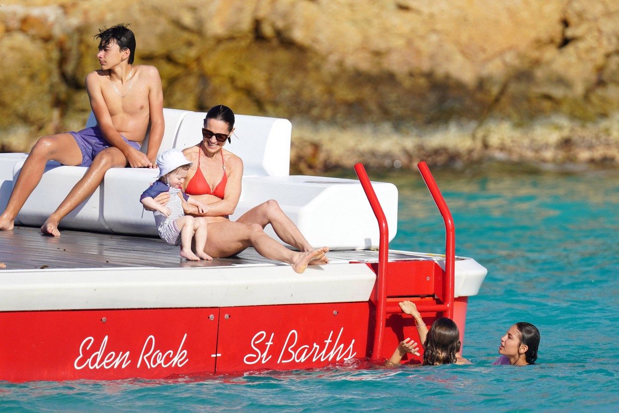 Pippa Middleton, pe o barcă cu unul dintre copiii ei, într-un costum de baie roșu din două piese