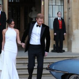Meghan Markle într-o rochie albă alături de Prințul Harry, care poartă costum, în timp ce părăsesc castelul Windsor