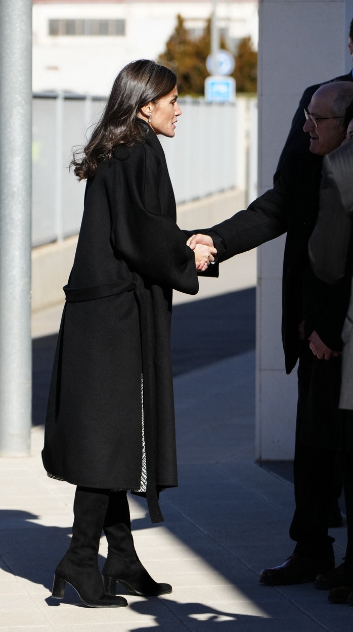 Regina Letizia se salută cu cineva îmbrăcată într-un palton negru