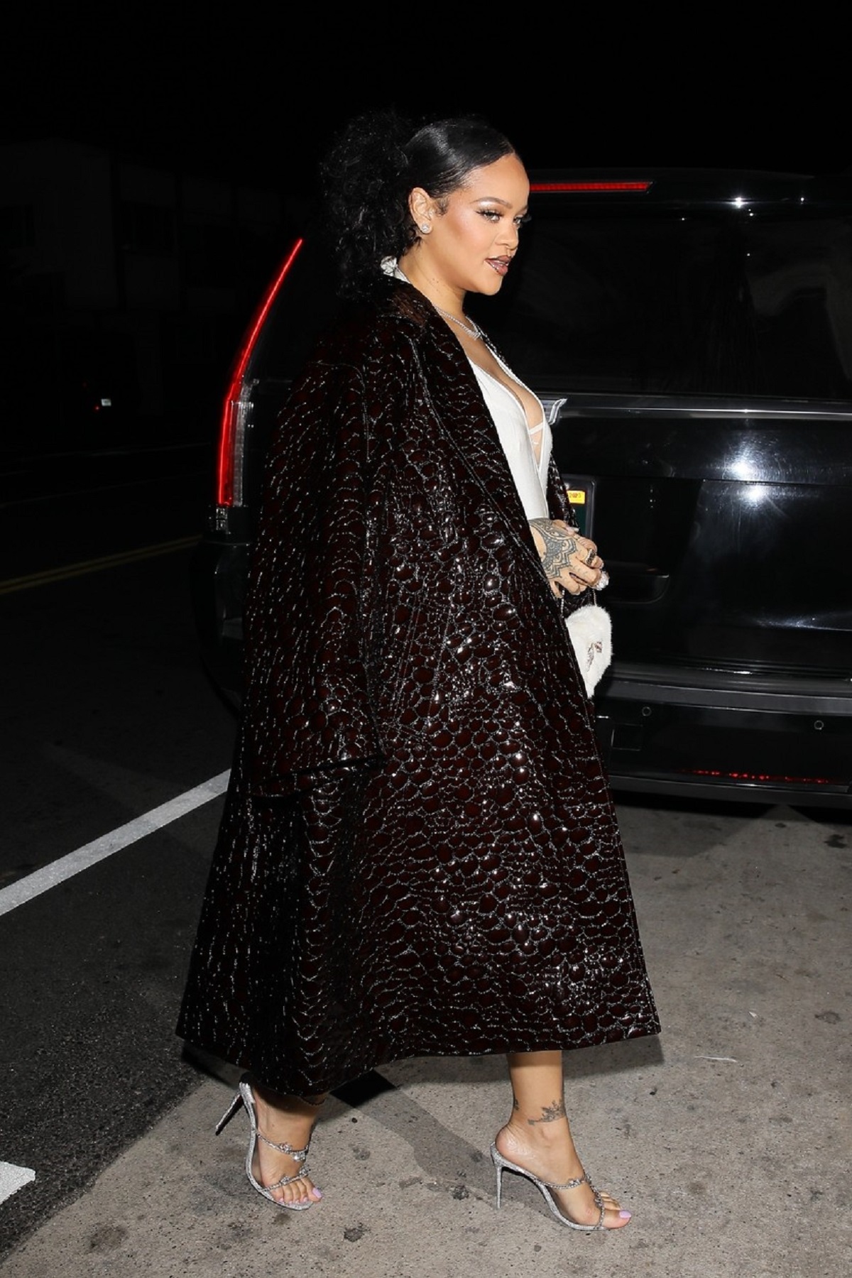 Rihanna într-o rochie albă și un palton maro