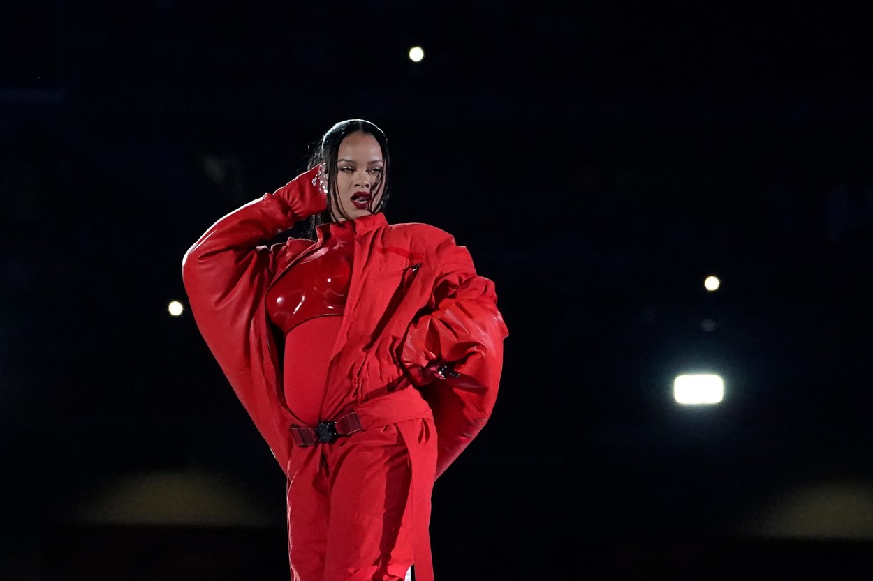 Rihanna pe scena de la Super Bowl 2023 dansează și face un show de zile mari fiind îmbrăcată într-o salopetă roșie ce îi scoate în evidență burtica de gravidă