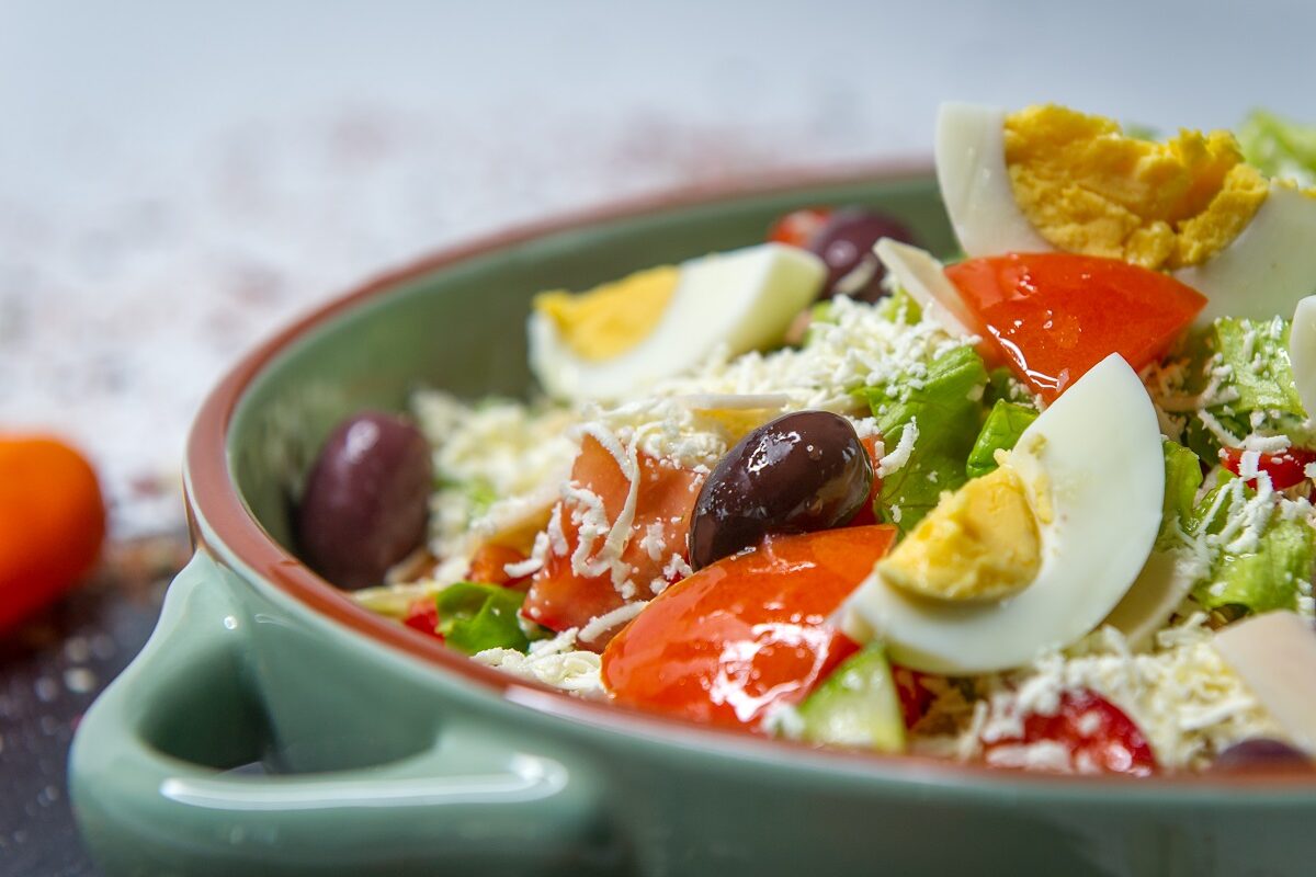 Un bol de salată cu multe legume sănătoase și un ou fiert