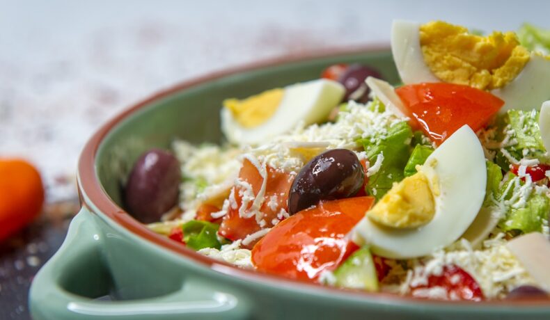 Un bol de salată cu multe legume sănătoase și un ou fiert