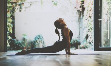 O femeie tânără face yoga pe o saltea de spumă