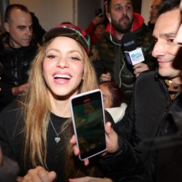 Shakira poartă o șapcă colorată pe cap și este asaltată de reporteri în cadrul unui eveniment
