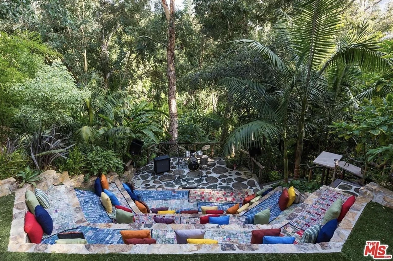 Un loc cu canapele și perne, pe iarbă, în curtea casei lui JLo din Bel Air