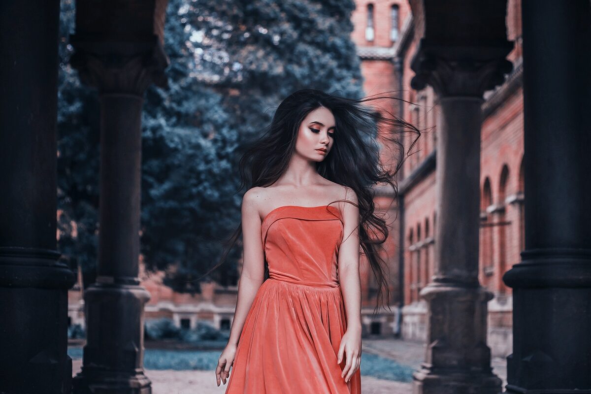 O femeie frumoasă într-o rochie orange care privește melancolic pentru a ilustra una dintre cele trei zodii ghinioniste pe 20 februarie 2023