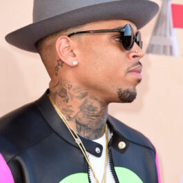 Chris Brown, cu o pălărie pe cap și ochelari de soare, la un eveniment