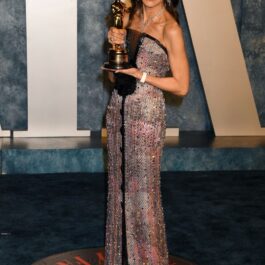 Michelle Yeoh, într-o rochie lungă, cu trofeul de la Oscar în mână, la petrecerea Vanity Fair Oscar Party 2023
