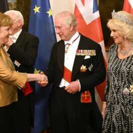Regele Charles dă mâna cu Angela Merkel, în timpul banchetului de stat din Germania