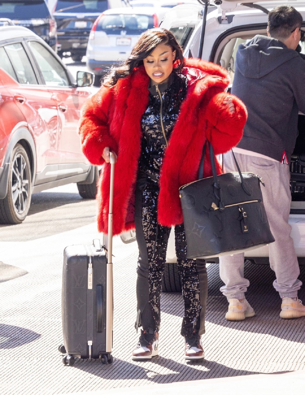 Blac Chyna într-o haină de blană roșie și cu bagajele sale în aeroportul din Los Angeles