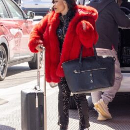 Blac Chyna în aeroportul din Los Angeles cu o haină de blană roșie