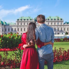 Un cuplu de îndrăgostiți care stă în fața unui palat din Viena, una dintre cele mai frumoase destinații din Europa în 2023