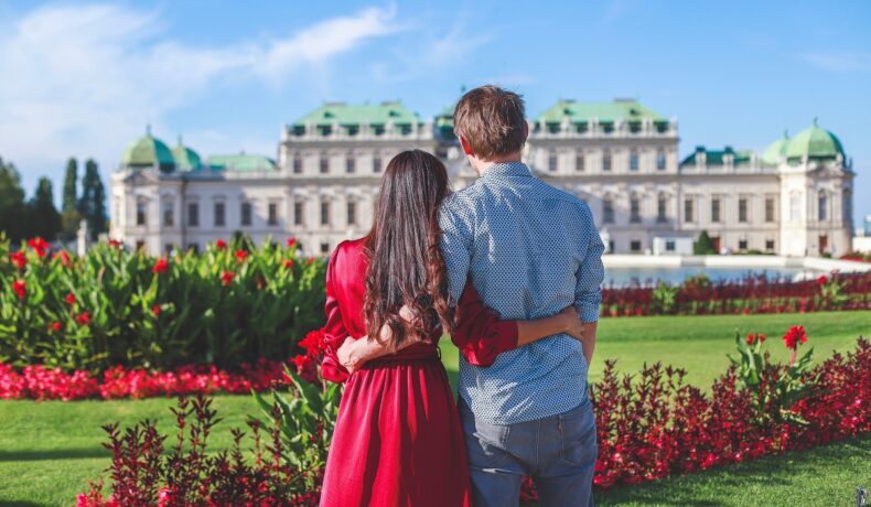 Un cuplu de îndrăgostiți care stă în fața unui palat din Viena, una dintre cele mai frumoase destinații din Europa în 2023