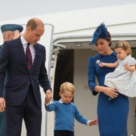 Kate Middleton cu prințesa Charlotte în brațe, alături de Prințul William și Prințul George, în timp ce coboară din avion