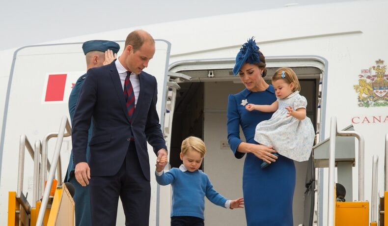 Kate Middleton cu prințesa Charlotte în brațe, alături de Prințul William și Prințul George, în timp ce coboară din avion