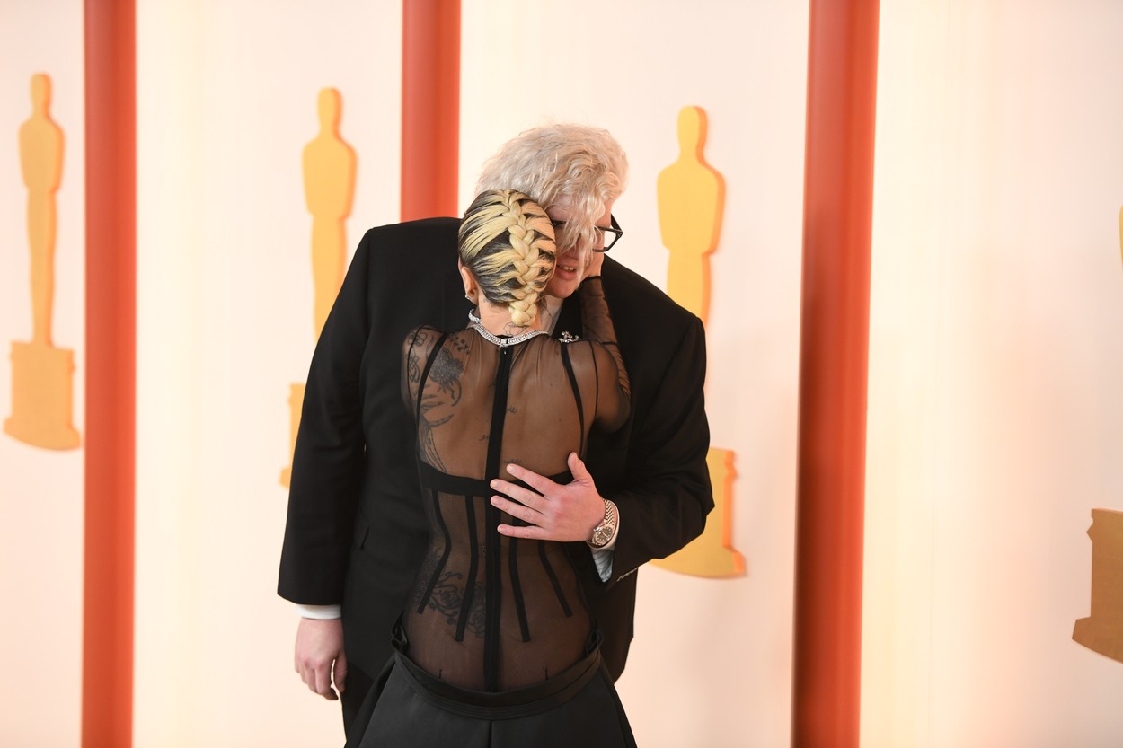 Lady Gaga se îmbrățișează cu un bărbat pe covorul roșu de la Premiile Oscar 2023